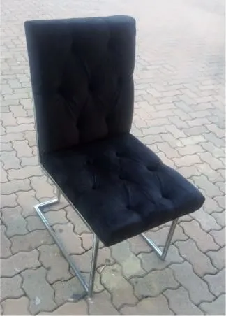 Finished bar stool with a buttoned black velvet seat and back on a bright steel cantilever frame