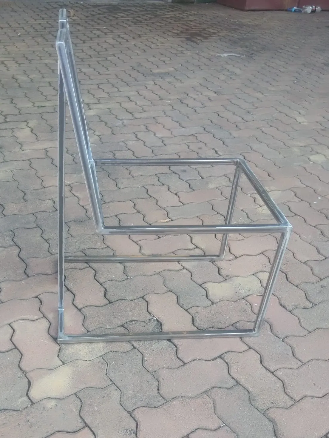 Mild steel chair frame in a cube form, seen from the side