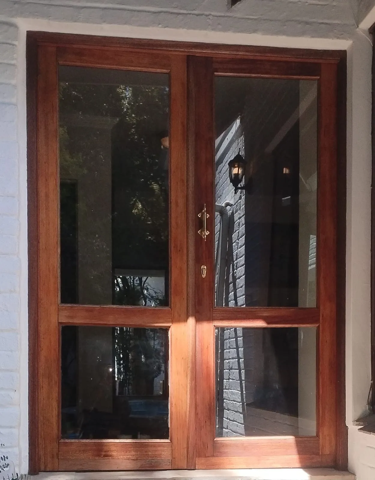 Restored hardwood french doors with brass furniture, the grain deep and even after oiling