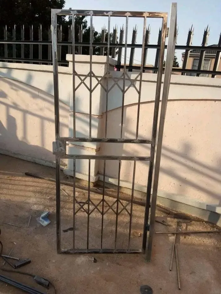 Mild steel pedestrian gate with a diamond-pattern infill panel top and bottom, welds dressed bright before priming